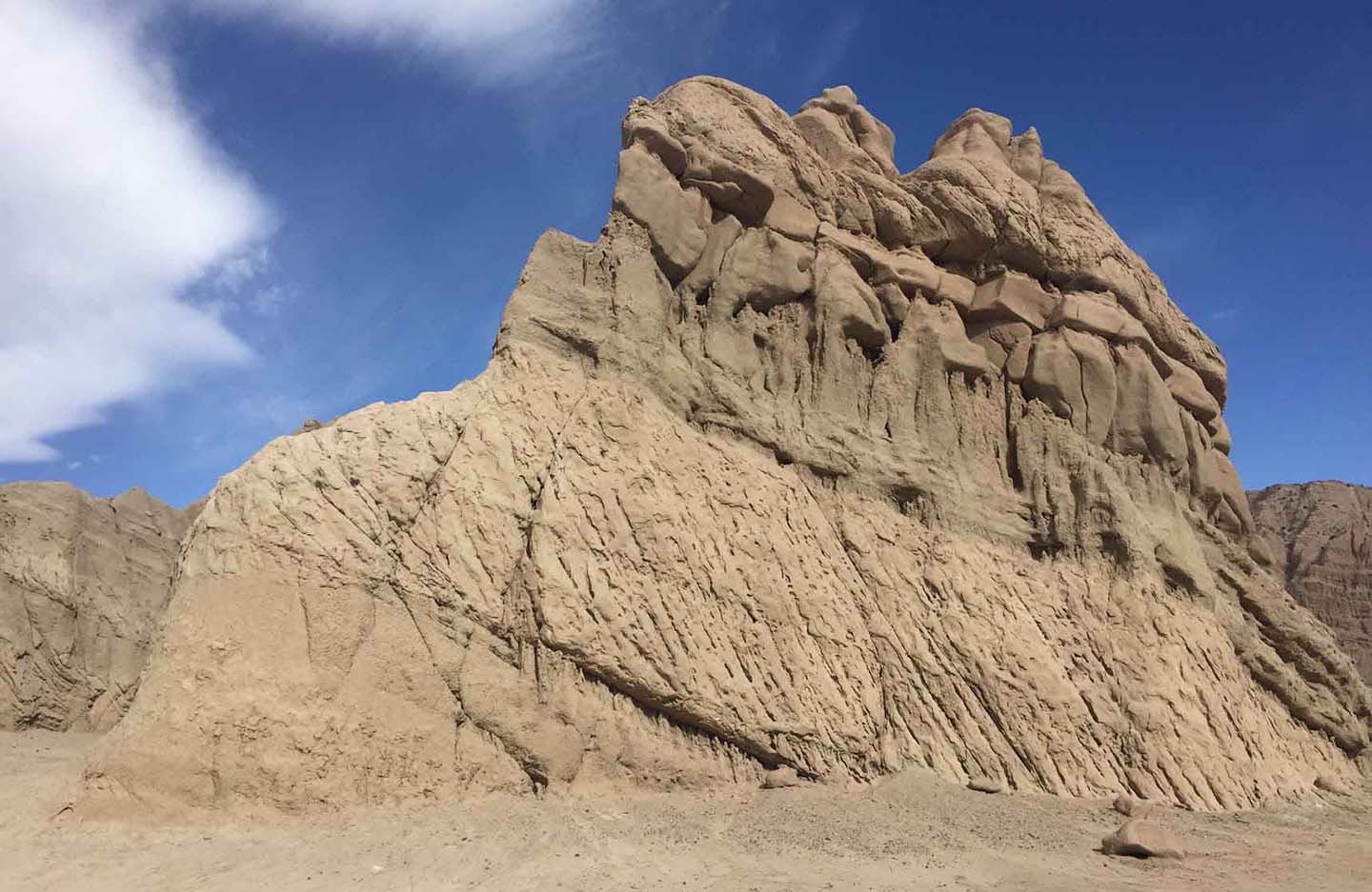 Tall eroded rock spire standing alone against a clear sky